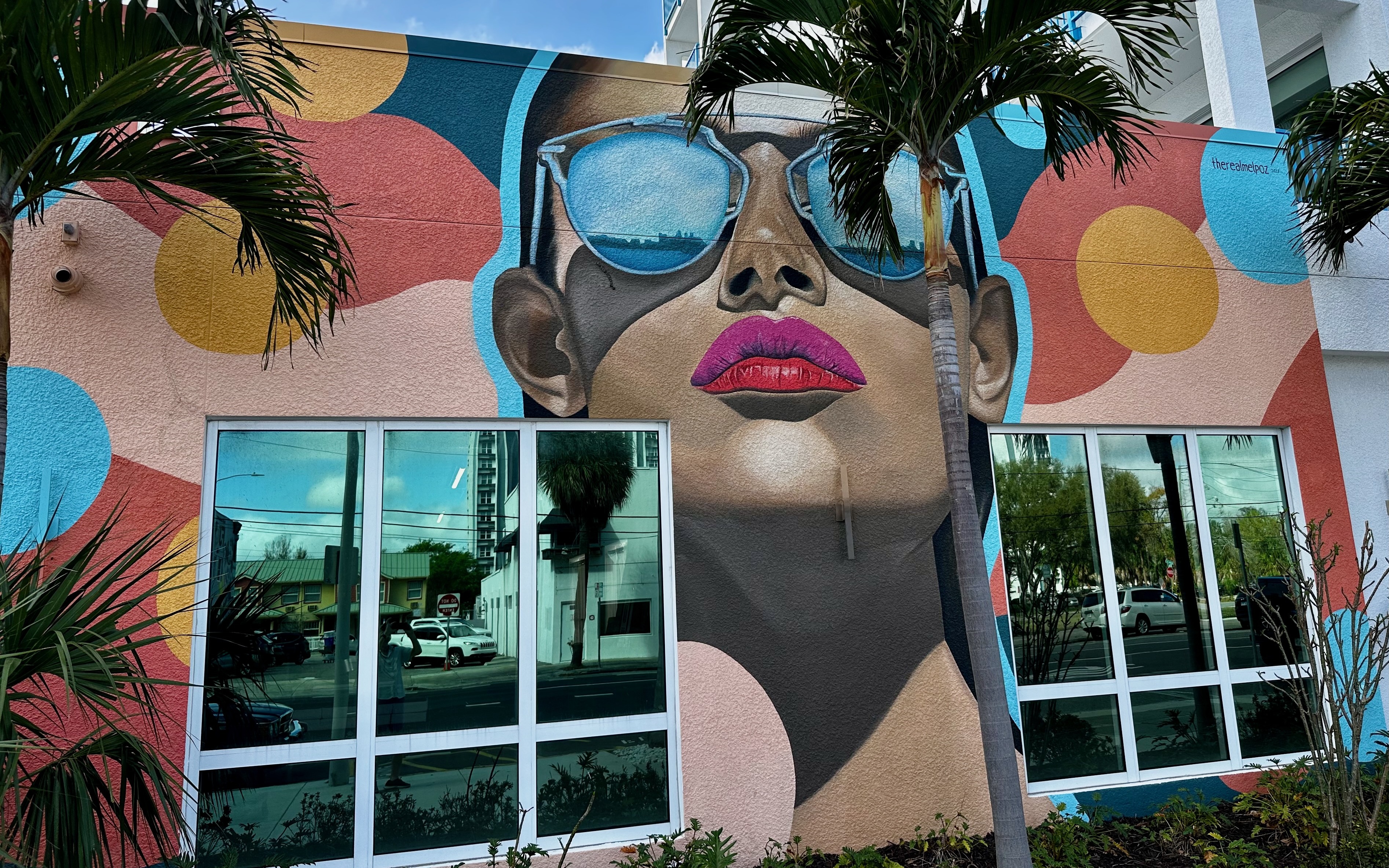 Posner mural of woman with mirrored sunglasses on polka-dot wall