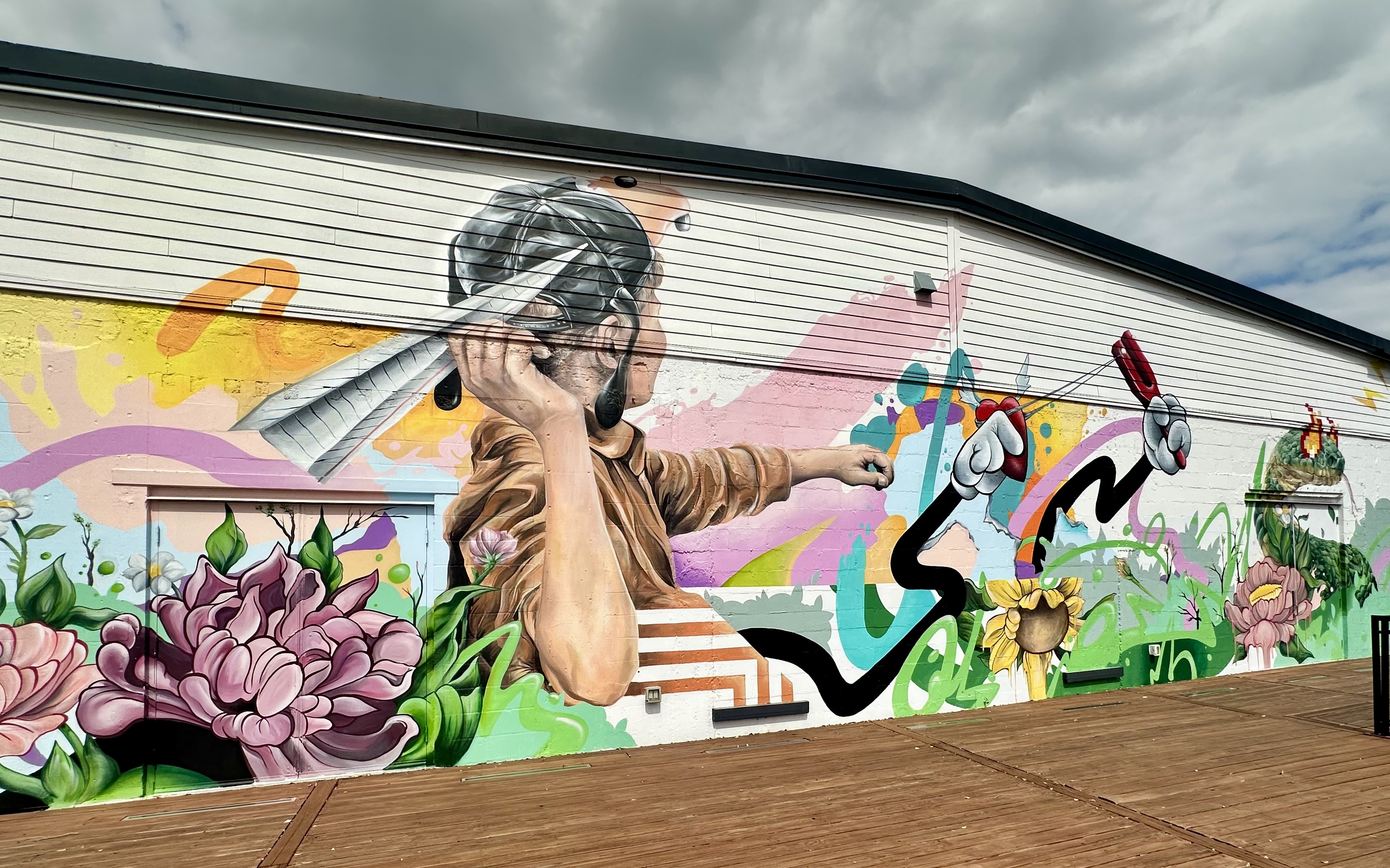 Frankie Gonzalez mural with child and slingshot
